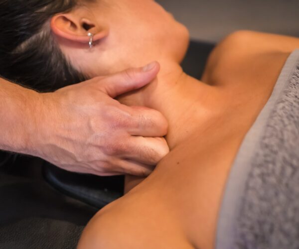 Detail of the neck massage to a young woman from a physiotherapist. Physio, osteopathy